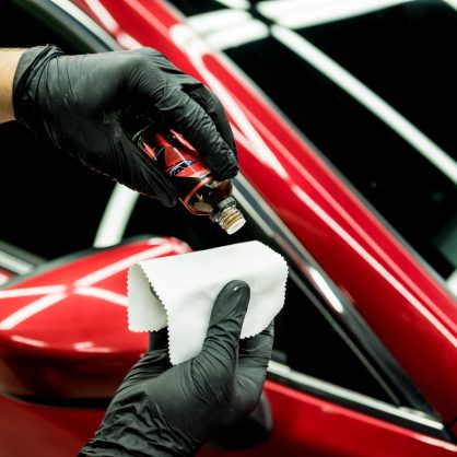 Car service worker applying nano coating on a car detail